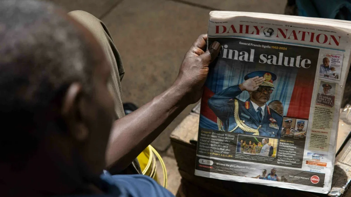 Seorang pria melihat surat kabar dengan judul kematian kepala pertahanan Jenderal Francis Omondi Ogolla dan se