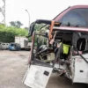 Seorang petugas melihat kondisi bus yang ringsek bagian depannya setelah terlibat kecelakaan di Tol Jakarta-Ci