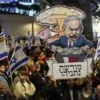Para pengunjuk rasa membawa plakat selama pertemuan yang diserukan oleh keluarga sandera Israel yang ditahan d