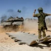Seorang tentara Israel mengarahkan tank, dekat perbatasan Israel-Gaza, di tengah konflik yang sedang berlangsu