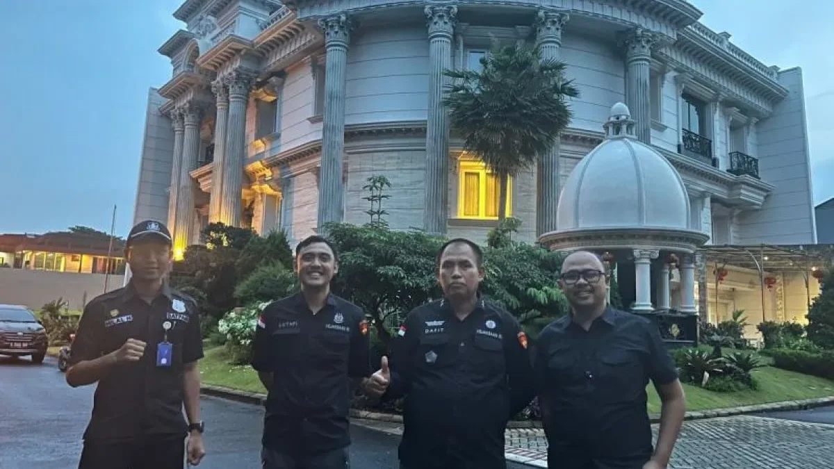 Tim Pelacakan Aset Direktorat Penyidikan Jampidsus Kejaksaan Agung berdiri di depan rumah sitaan milik tersang