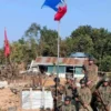 Kelompok bersenjata AA mengibarkan bendera mereka setelah merebut pos terdepan rezim di puncak bukit di Kyaukt