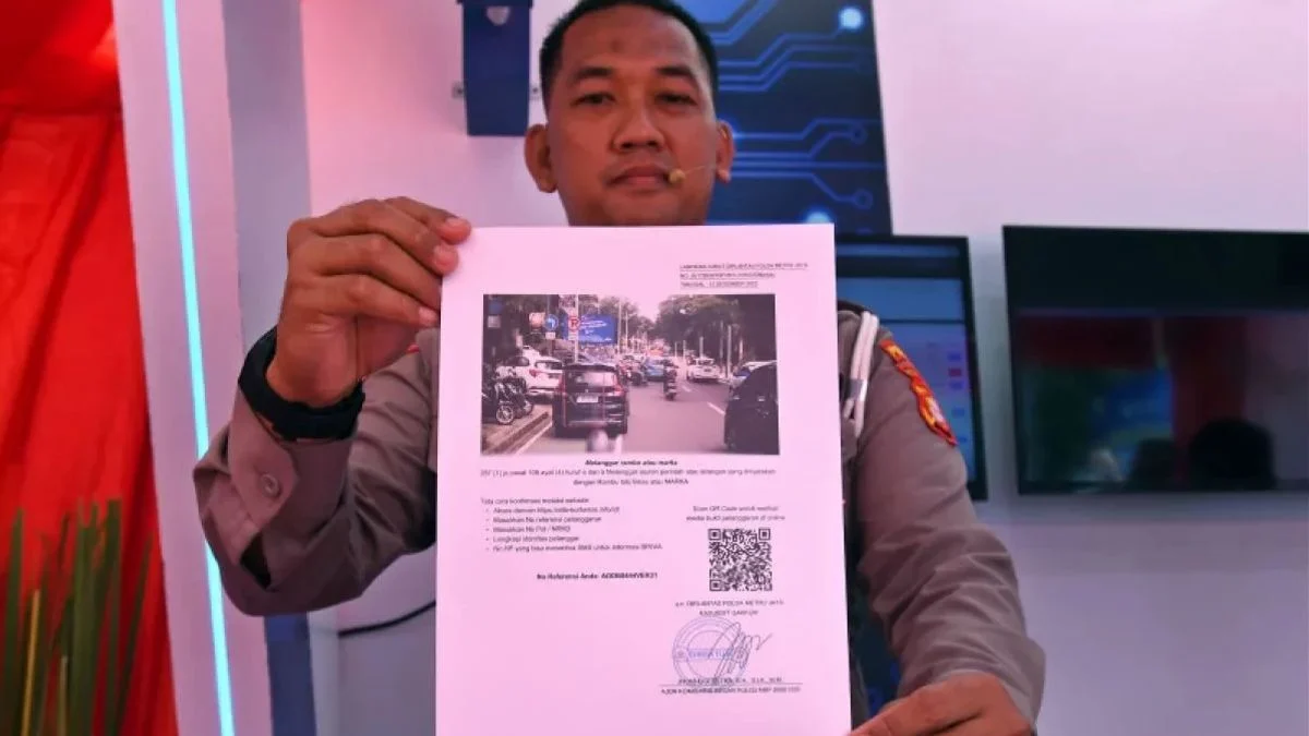 Petugas kepolisian menunjukkan contoh surat tilang dari sistem tilang elektronik (ETLE) yang diluncurkan di Ma
