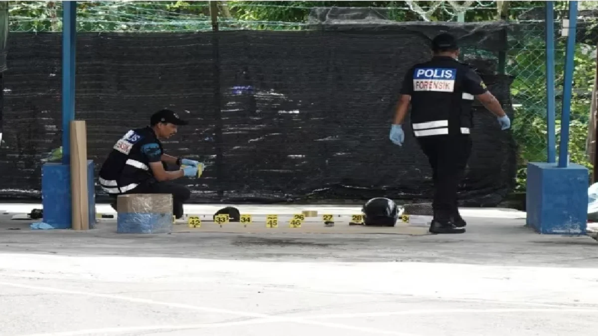 Petugas forensik kepolisian mengambil gambar di luar kantor polisi Ulu Tiram, Negara Bagian Johor, Malaysia, 1