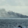 Perahu karet RSS Supreme dengan lambung kaku di sekitar kapal yang terbakar menyusul kebakaran di dua kapal ta